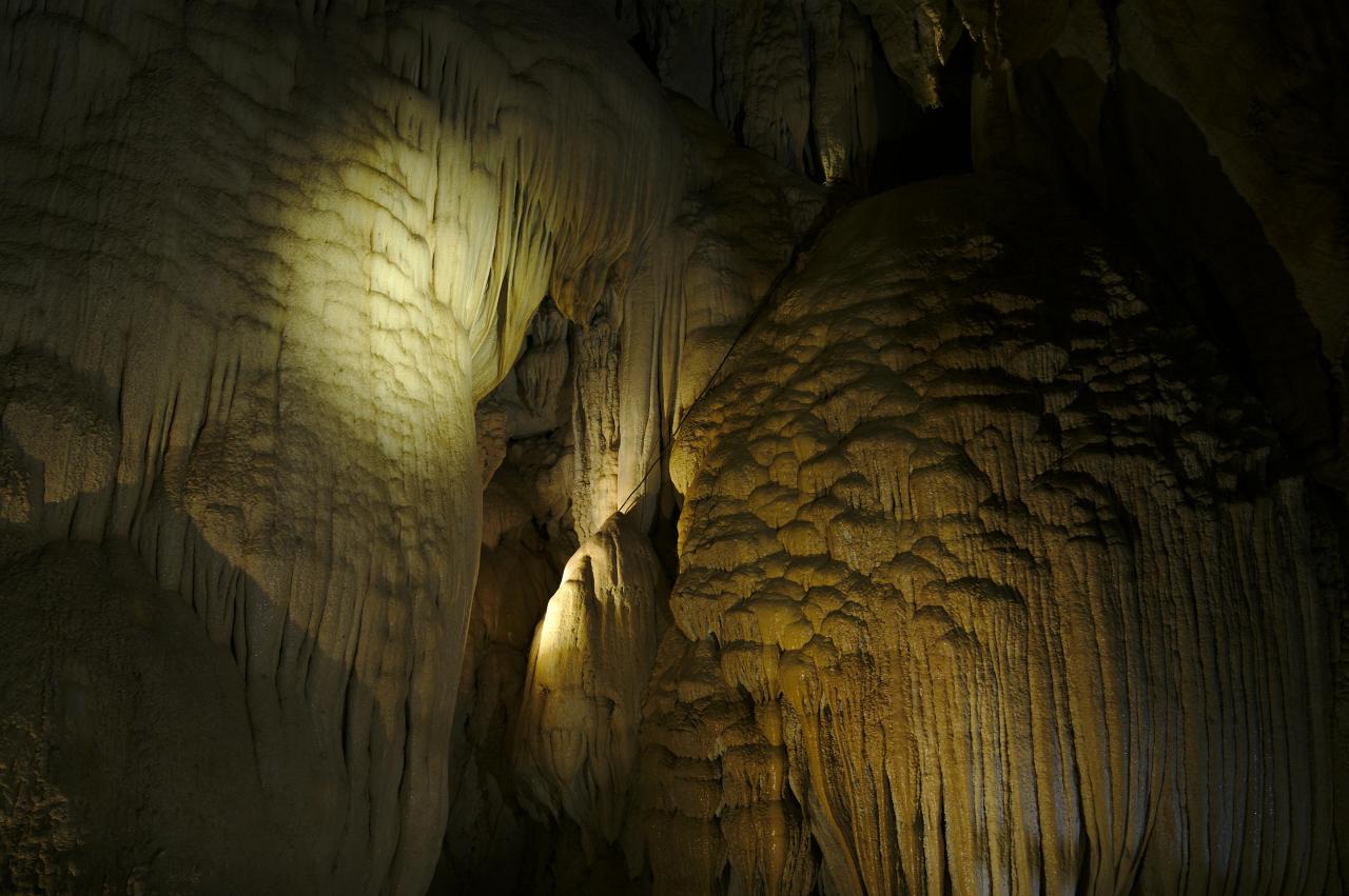 underground cavern stalactites illuminated exploration