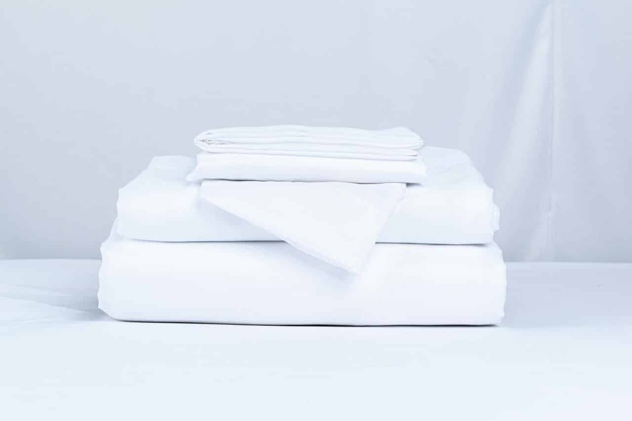 white folded bed linens stack