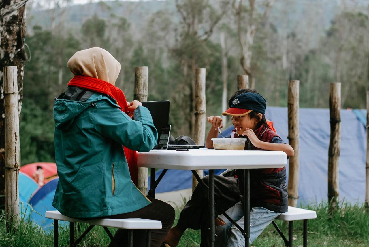 camping family eating meal outdoor picnic table sunset