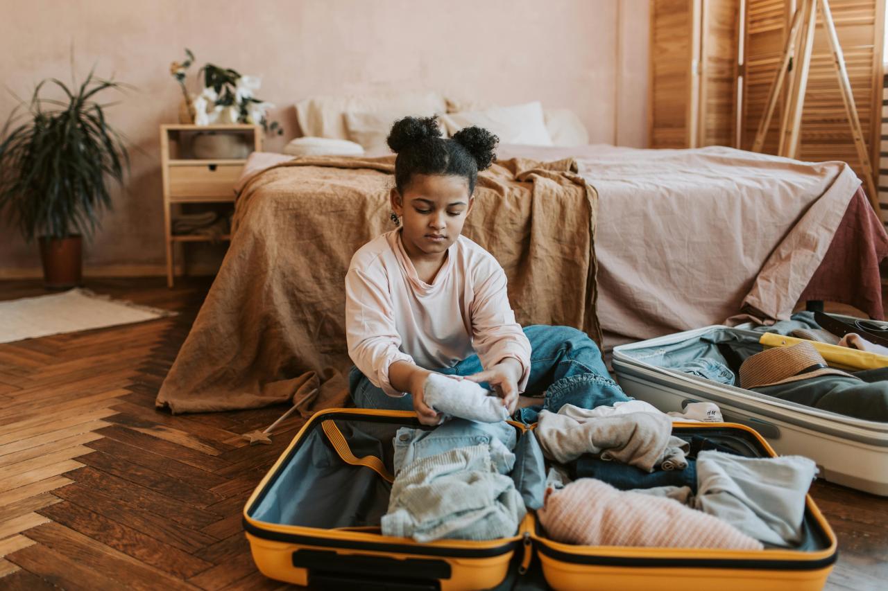 family unpacking suitcases vacation rental bedroom