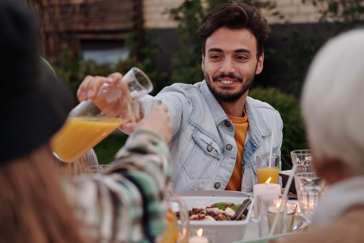 group of friends enjoying summer dinner on vacation villa terrace