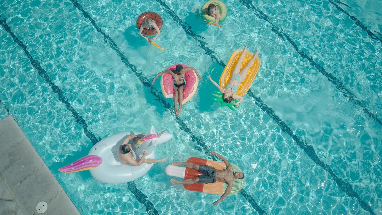 two families enjoying swimming pool together sunshine